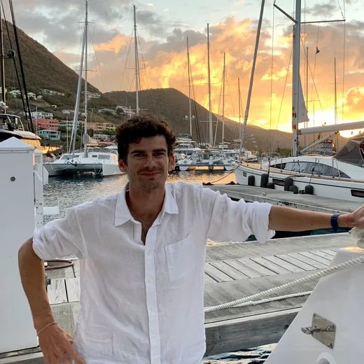 Jean-Charles Levenne sur le ponton, à côté d'un catamaran, au coucher du soleil à Tortola (îles Vierges britanniques)